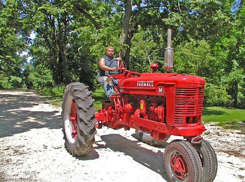 Ben Johnson on his shiny red restored Farmall M tractor